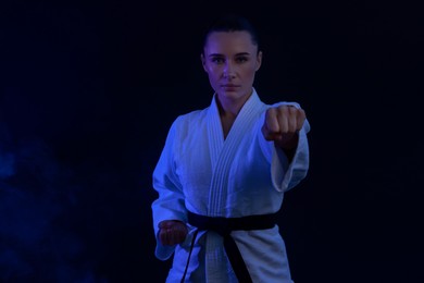 Photo of Karate fighter in kimono on dark background