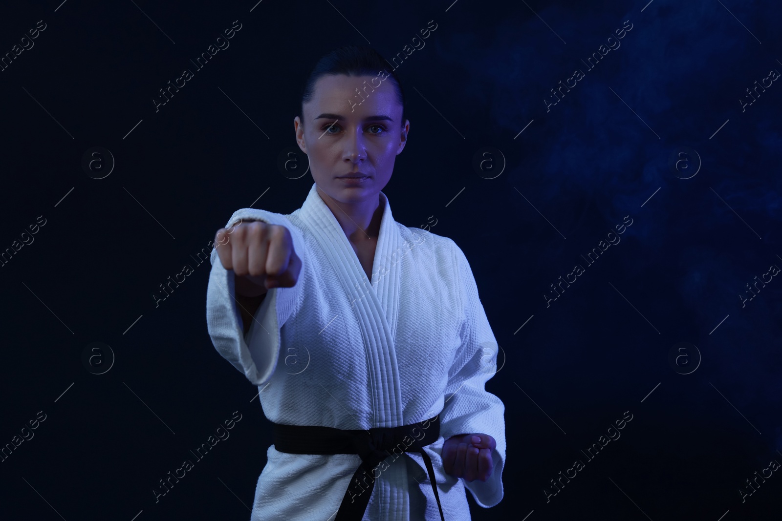 Photo of Karate fighter in kimono on dark background