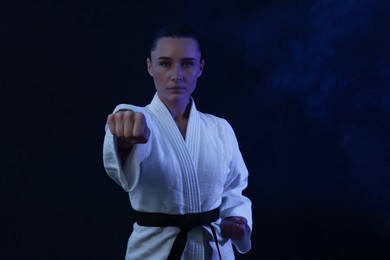 Photo of Karate fighter in kimono on dark background