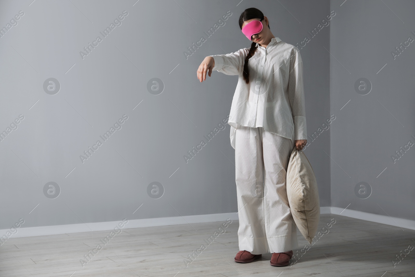 Photo of Young woman suffering from sleepwalking at home, space for text