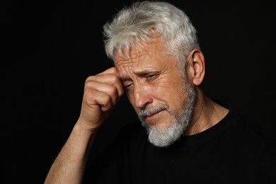 Photo of Sad senior man crying on black background