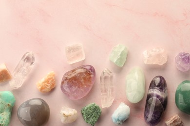 Photo of Beautiful natural gemstones on light pink background, flat lay