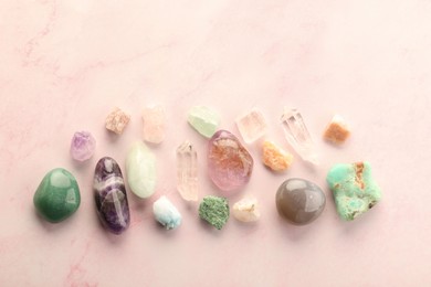 Photo of Beautiful natural gemstones on light pink background, flat lay