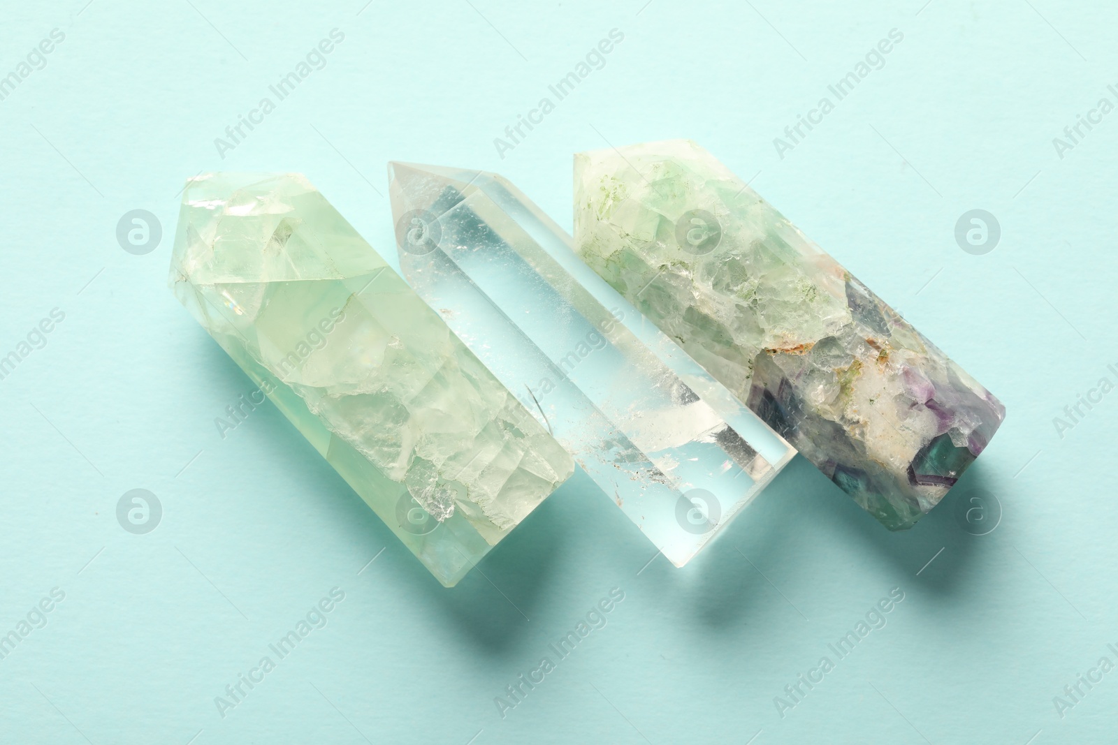 Photo of Beautiful natural gemstones on light blue background, flat lay