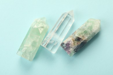 Beautiful natural gemstones on light blue background, flat lay