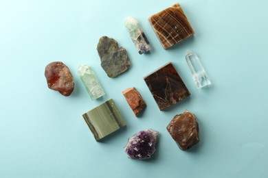 Photo of Beautiful natural gemstones on light blue background, flat lay