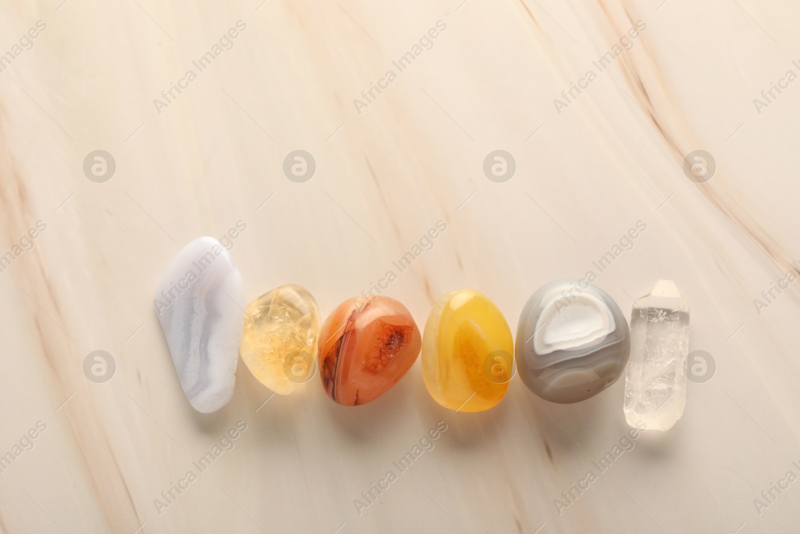 Photo of Beautiful natural gemstones on light background, flat lay. Space for text