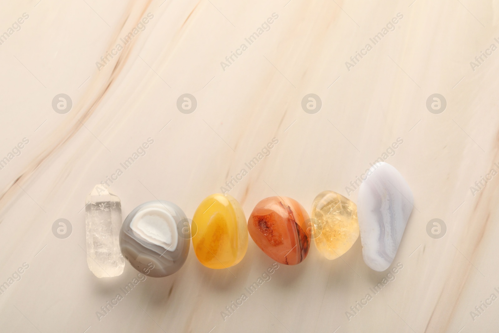 Photo of Beautiful natural gemstones on light background, flat lay. Space for text