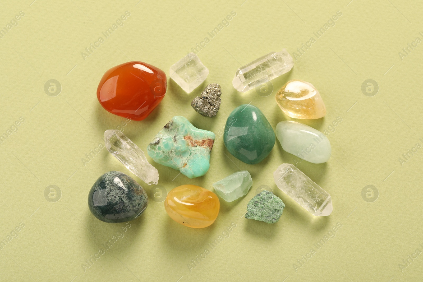 Photo of Beautiful natural gemstones on light green background, flat lay