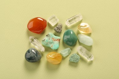 Photo of Beautiful natural gemstones on light green background, flat lay