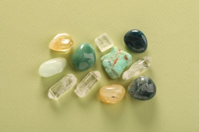 Photo of Beautiful natural gemstones on light green background, flat lay