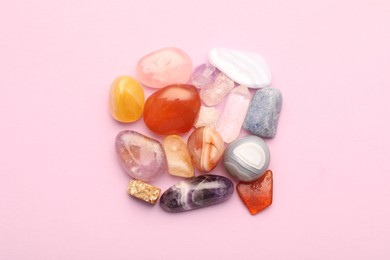 Beautiful natural gemstones on light pink background, flat lay