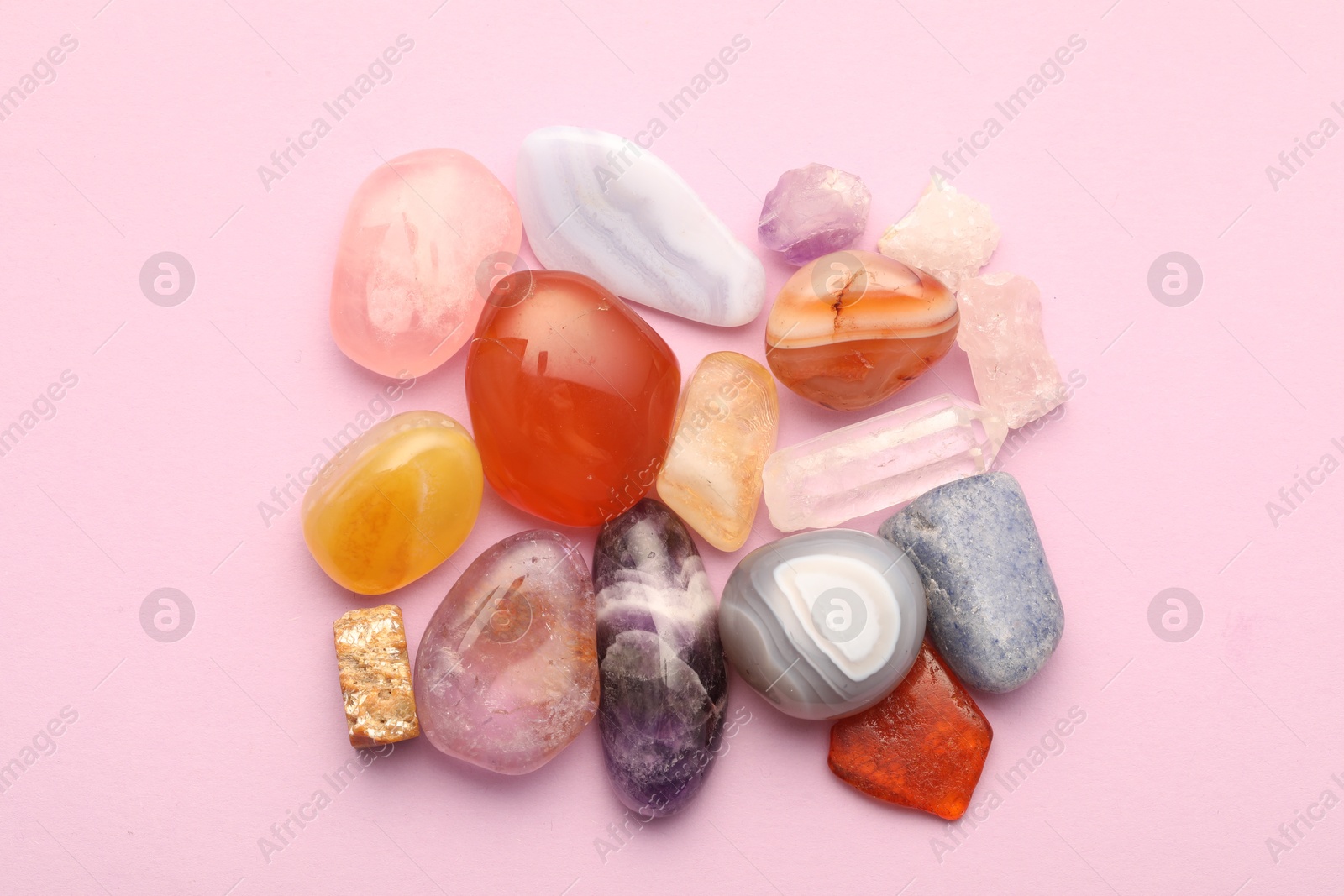 Photo of Beautiful natural gemstones on light pink background, flat lay