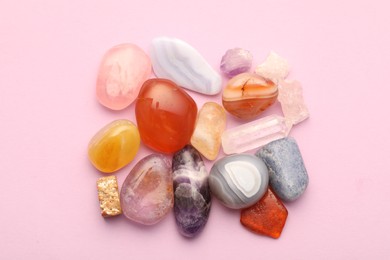 Photo of Beautiful natural gemstones on light pink background, flat lay