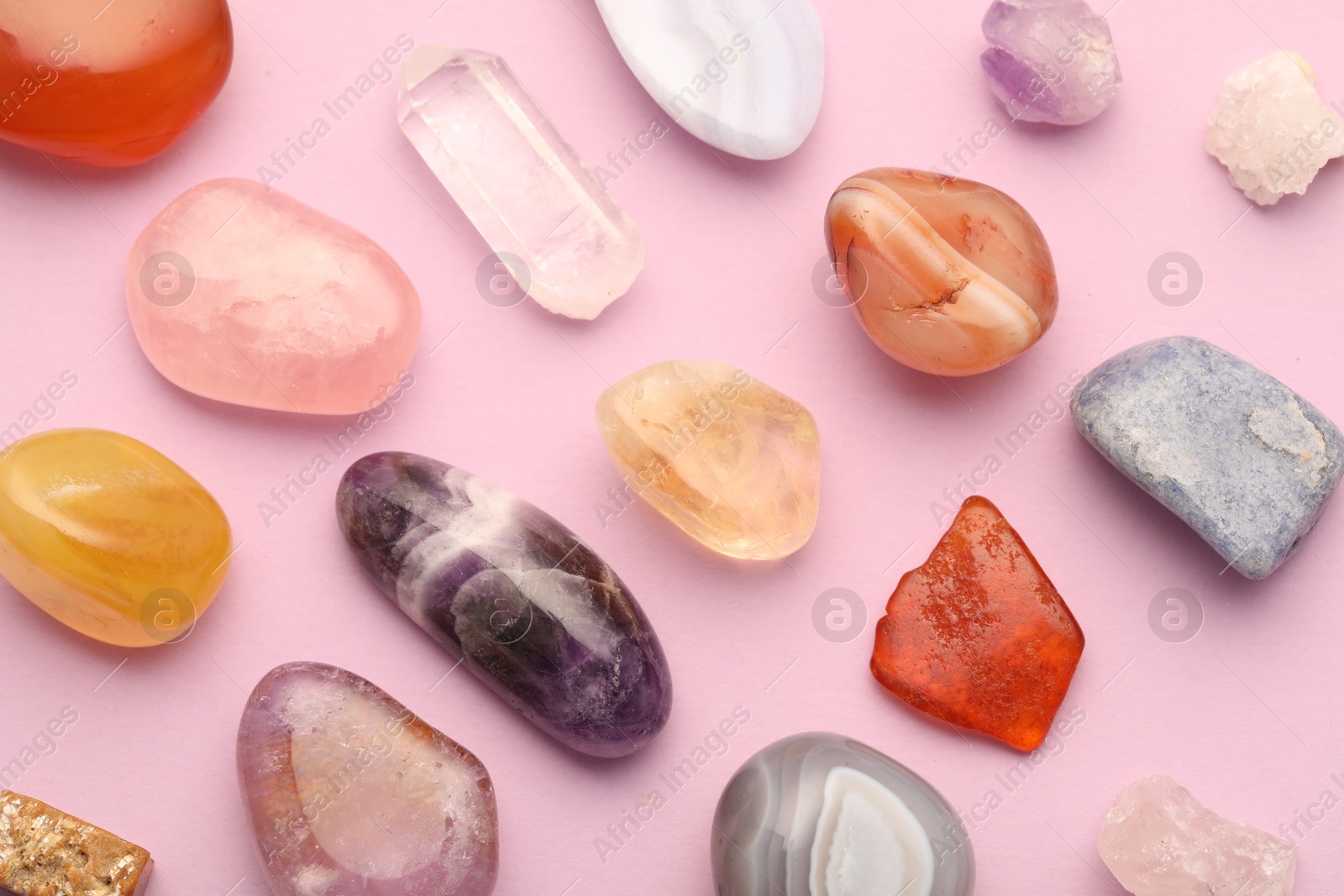 Photo of Beautiful natural gemstones on light pink background, flat lay