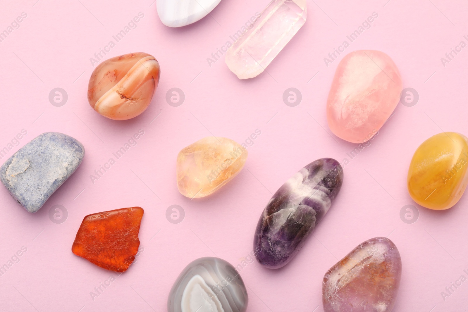 Photo of Beautiful natural gemstones on light pink background, flat lay