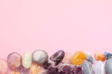 Photo of Beautiful natural gemstones on light pink background, flat lay. Space for text