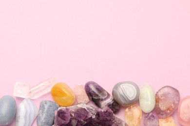 Photo of Beautiful natural gemstones on light pink background, flat lay. Space for text