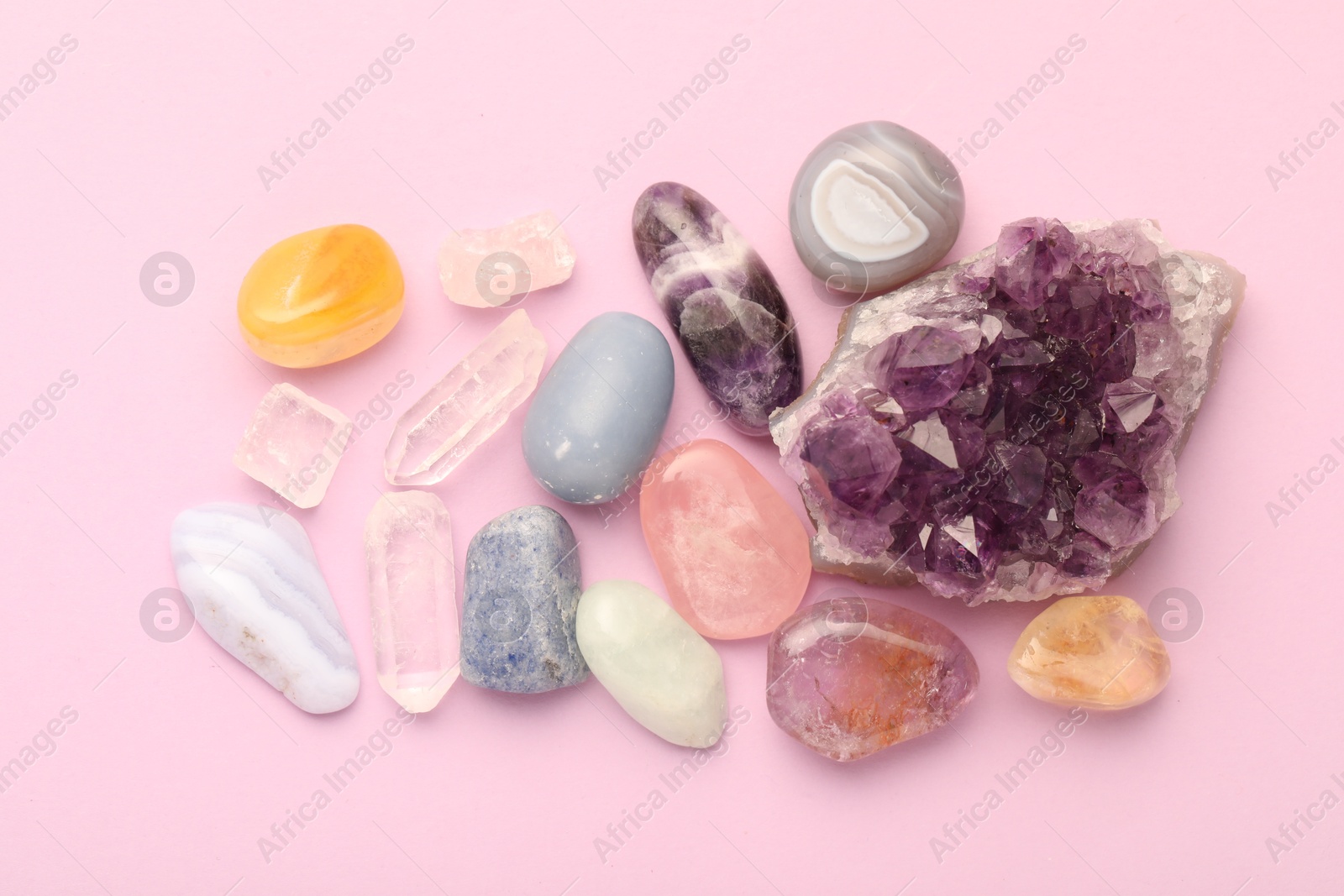 Photo of Beautiful natural gemstones on light pink background, flat lay