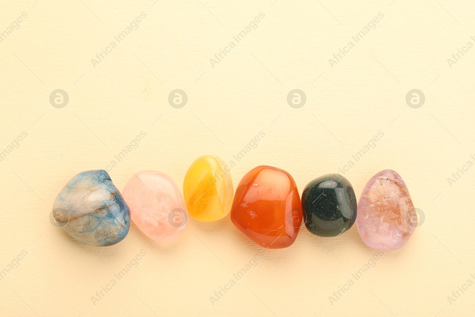 Photo of Beautiful natural gemstones on beige background, flat lay. Space for text