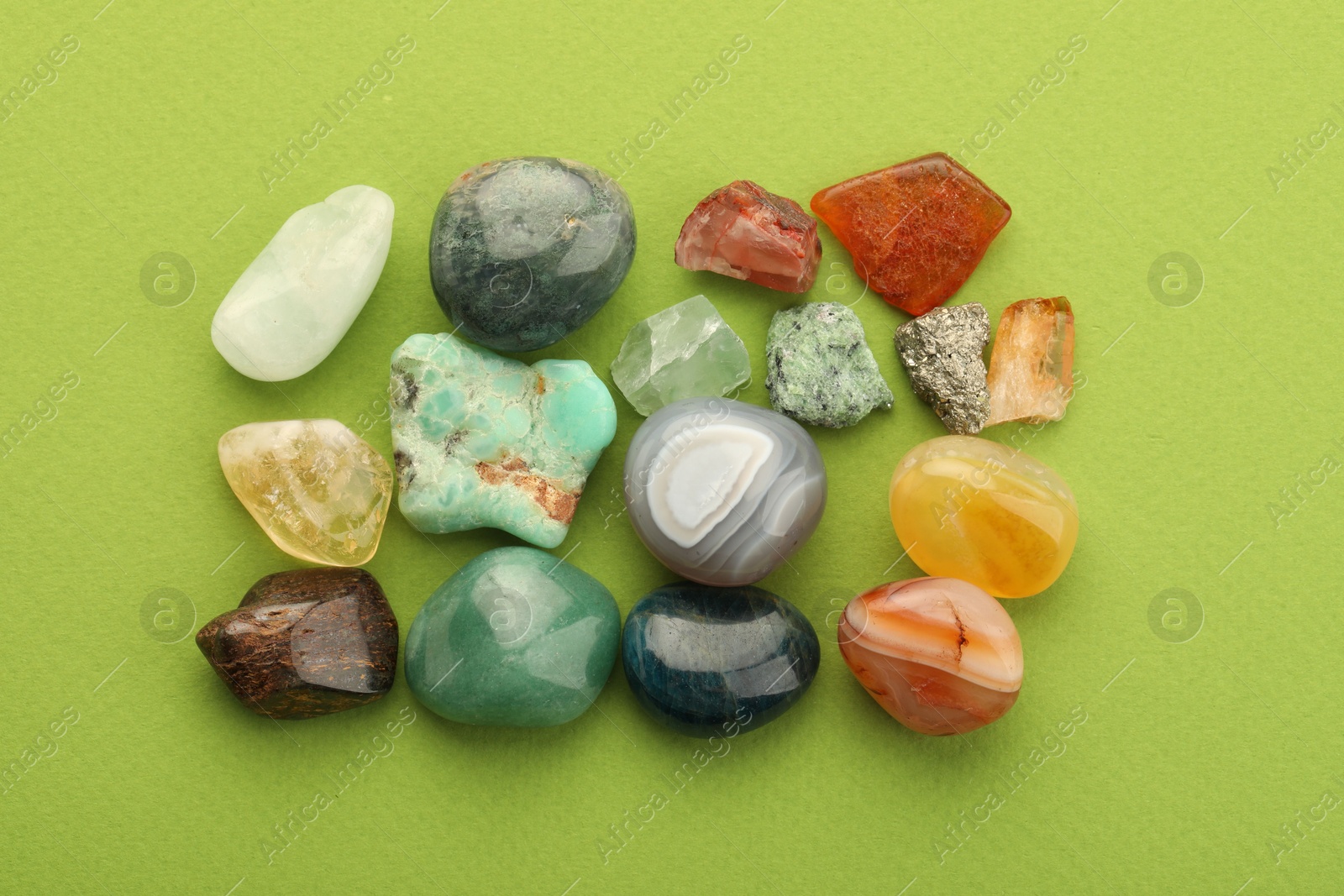 Photo of Beautiful natural gemstones on green background, flat lay