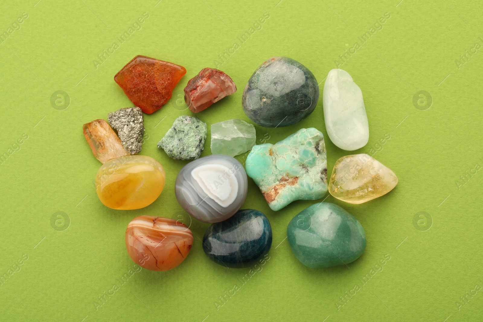 Photo of Beautiful natural gemstones on green background, flat lay