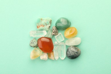 Photo of Beautiful natural gemstones on turquoise background, flat lay