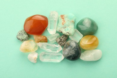 Photo of Beautiful natural gemstones on turquoise background, flat lay