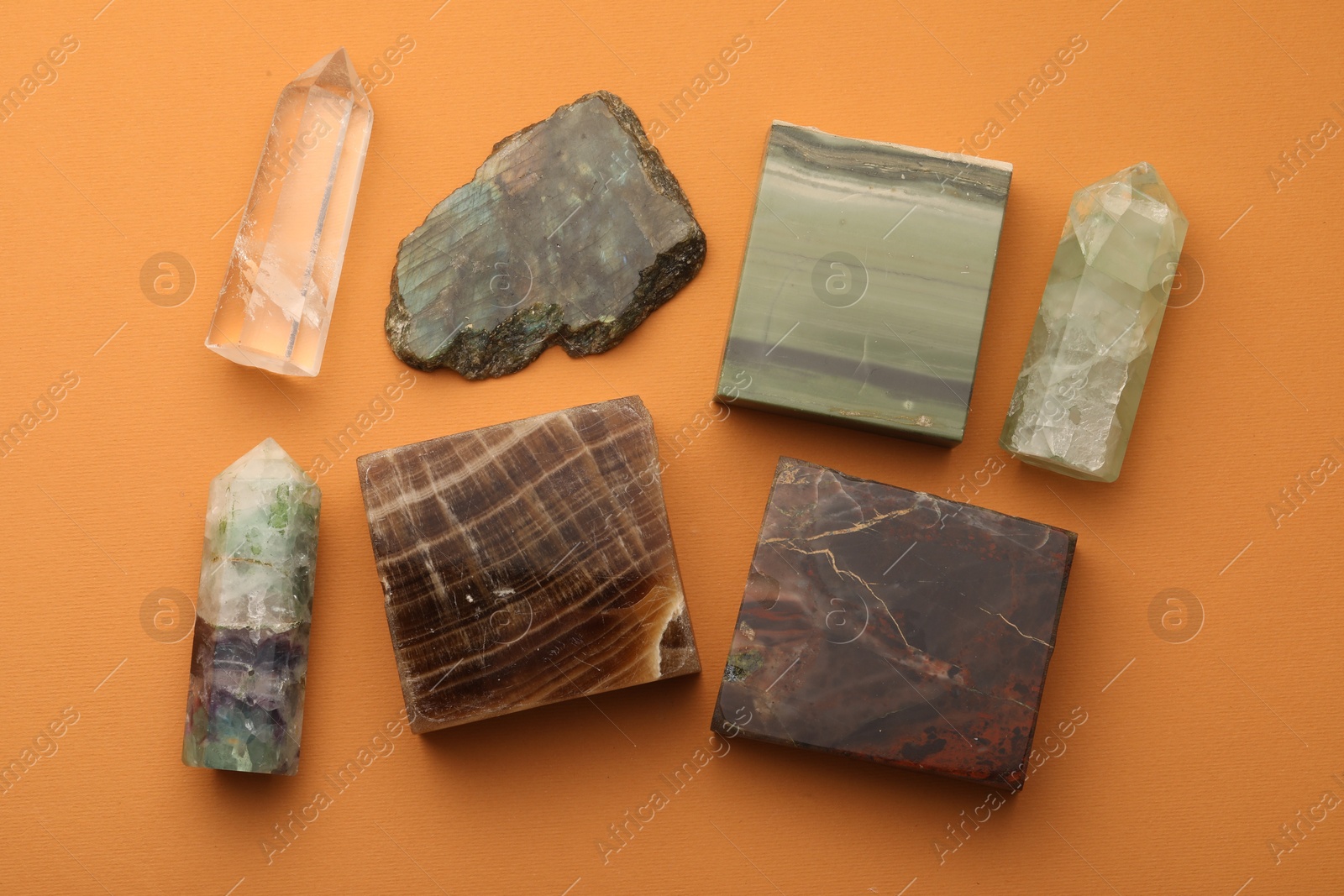 Photo of Beautiful natural gemstones on orange background, flat lay