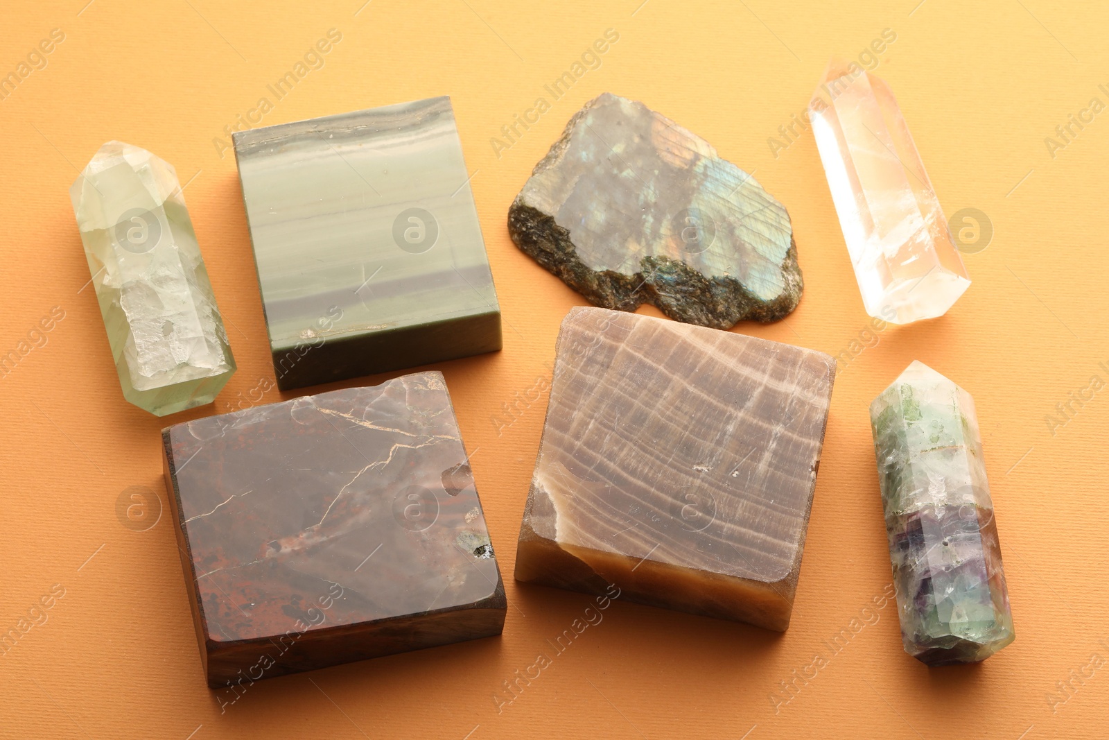 Photo of Beautiful natural gemstones on orange background, above view