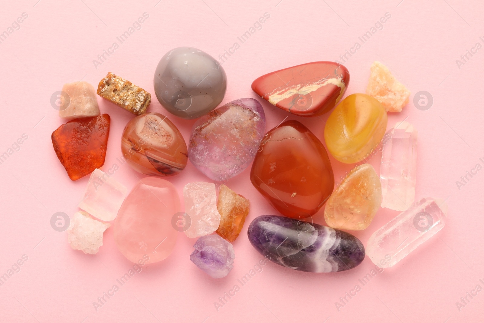 Photo of Beautiful natural gemstones on light pink background, flat lay