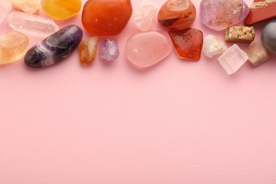 Photo of Beautiful natural gemstones on light pink background, flat lay. Space for text