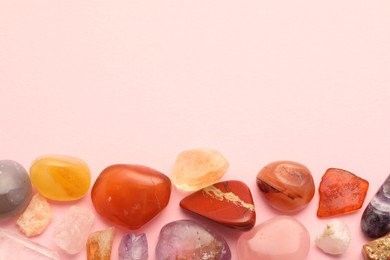 Photo of Beautiful natural gemstones on light pink background, flat lay. Space for text