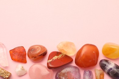 Photo of Beautiful natural gemstones on light pink background, flat lay. Space for text