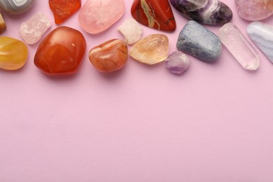 Photo of Beautiful natural gemstones on light pink background, flat lay. Space for text