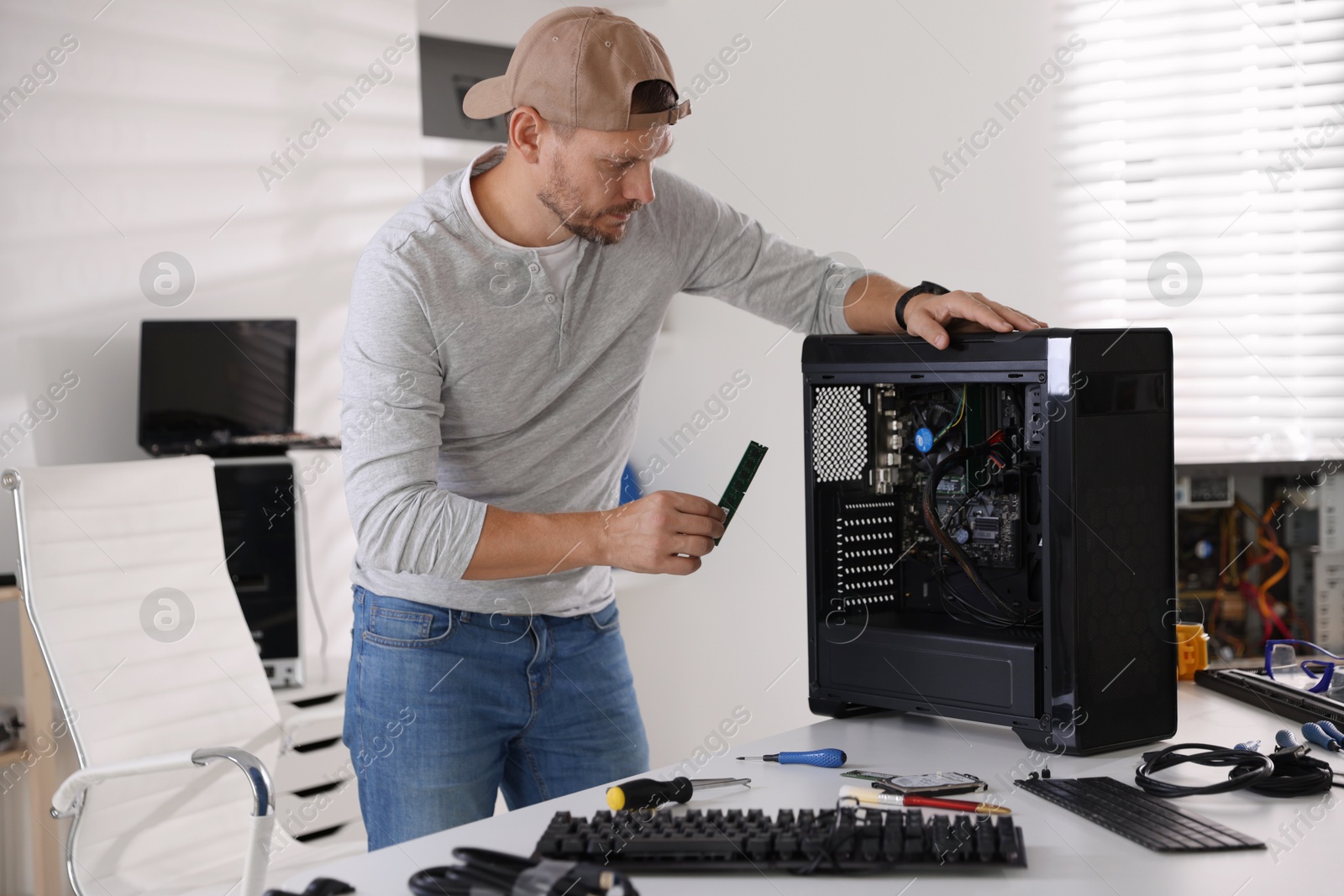 Photo of Man assembling new computer at white table