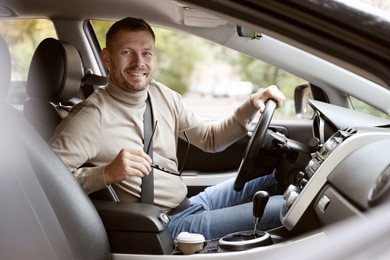 Photo of Happy man behind steering wheel of modern car