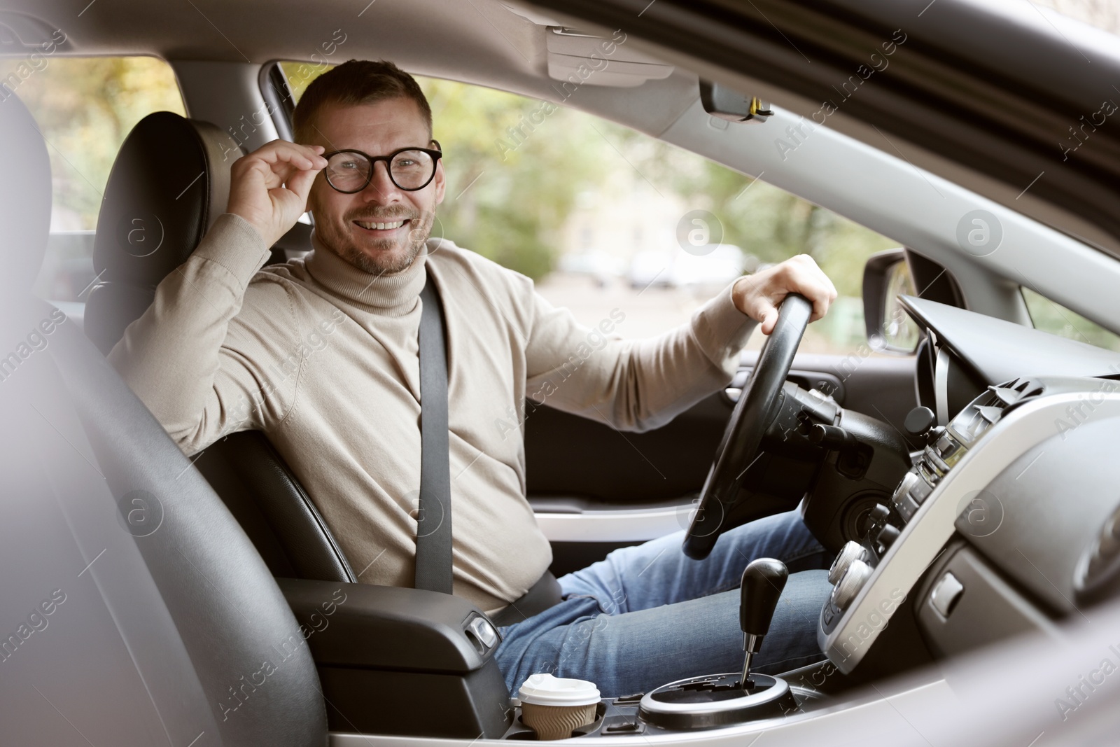 Photo of Happy man behind steering wheel of modern car