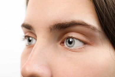 Photo of Closeup view of young woman with beautiful blue eyes on white background