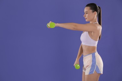 Photo of Woman exercising with dumbbells on purple background, space for text