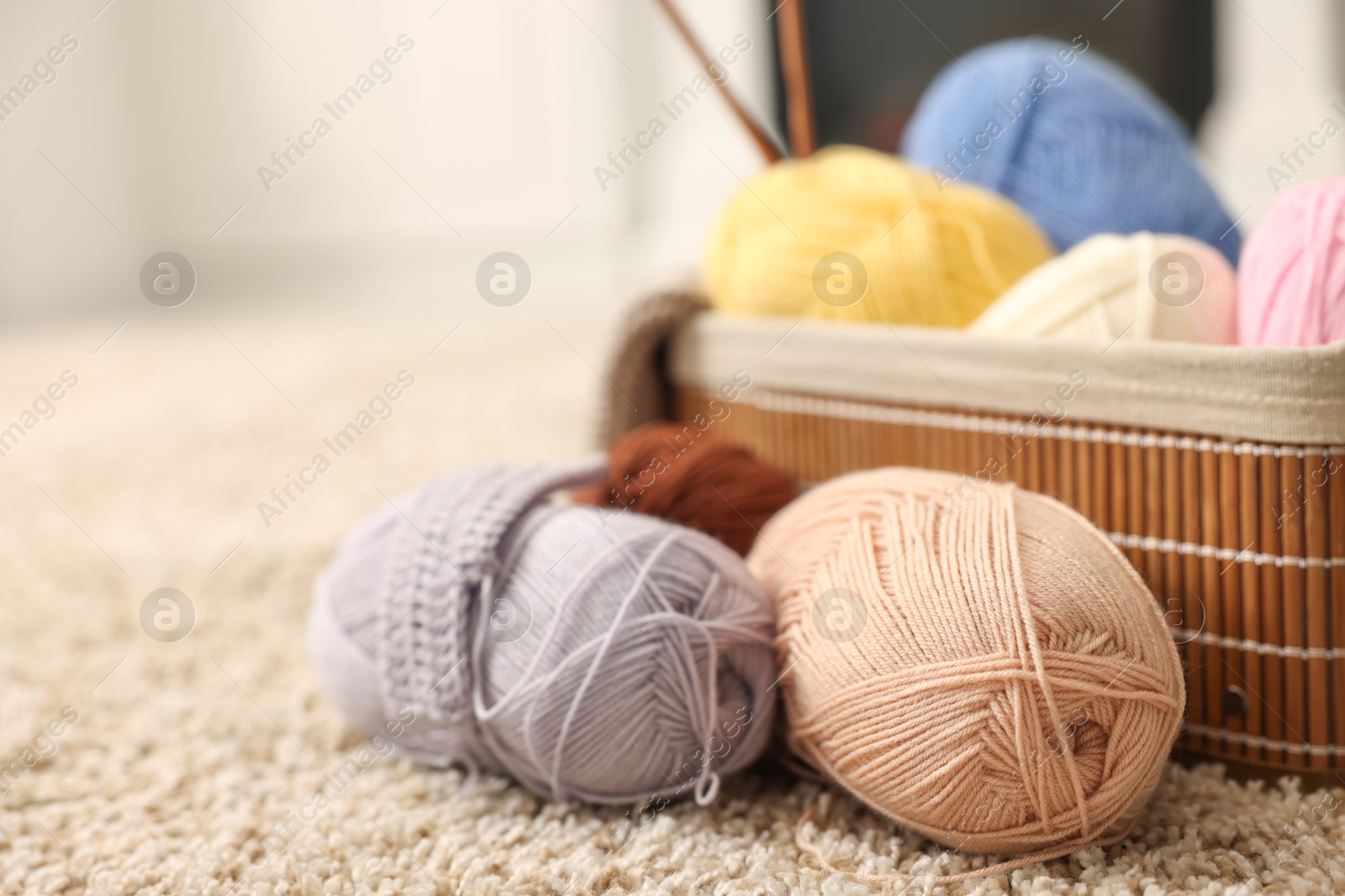 Photo of Colorful yarns, crochet sample and basket on soft carpet, closeup. Space for text