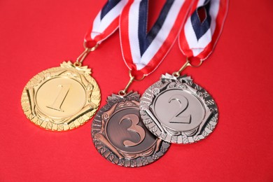 Photo of Golden, silver and bronze medals on red background, closeup