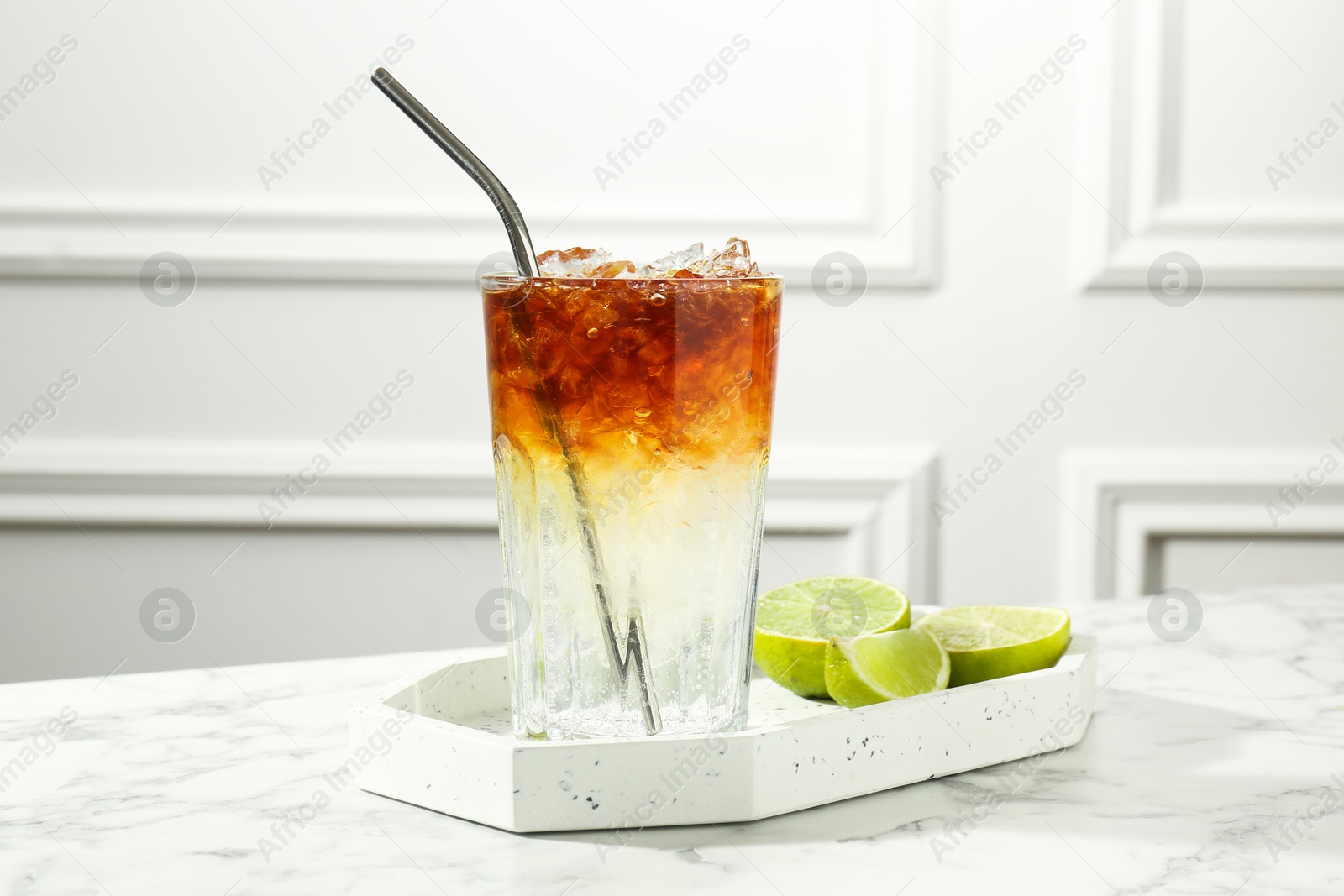 Photo of Refreshing espresso tonic drink and lime on white marble table