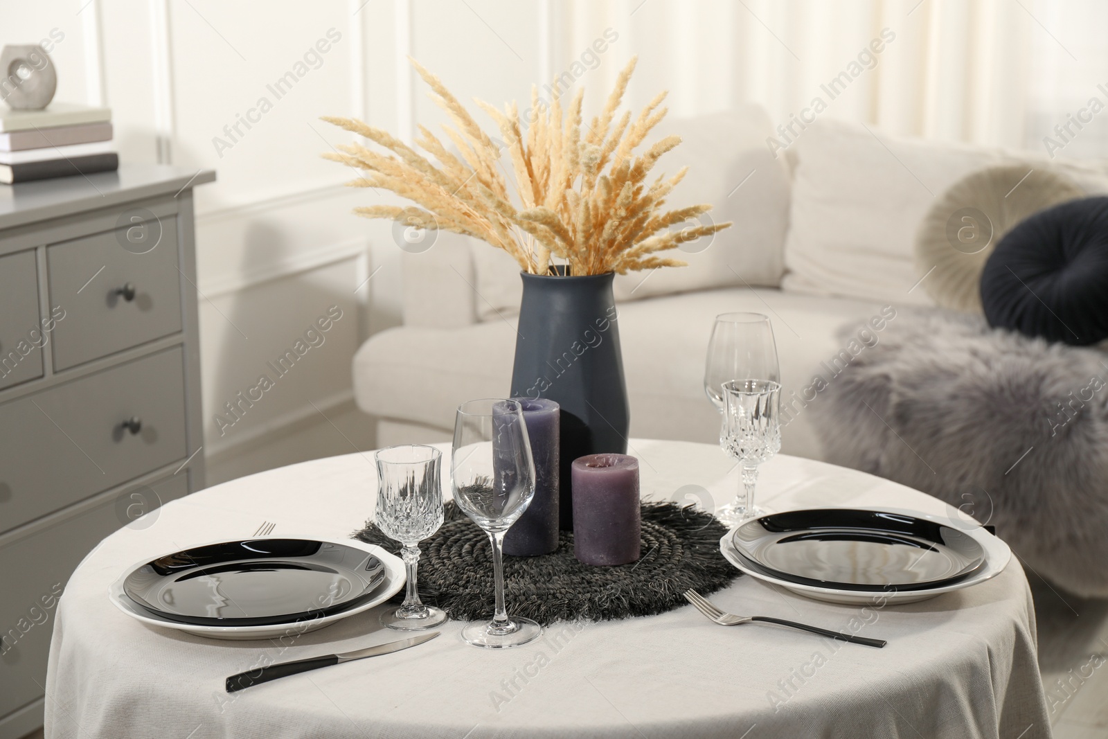 Photo of Stylish table setting with black dishware in dining room