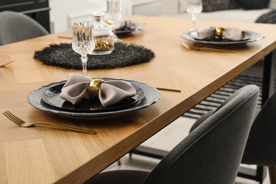 Photo of Stylish table setting with black dishware in dining room, closeup