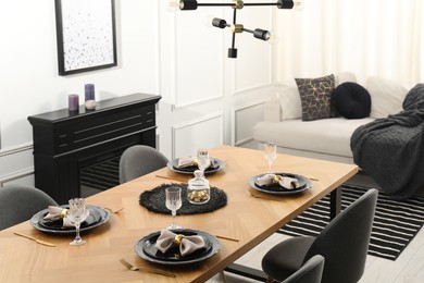 Photo of Stylish table setting with black dishware in dining room