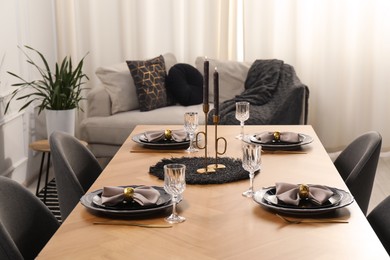 Photo of Stylish table setting with black dishware in dining room