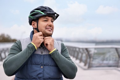 Photo of Man with helmet and bicycle outdoors, space for text