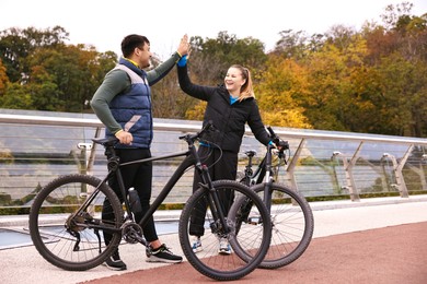 Photo of Beautiful happy couple with bicycles spending time together outdoors