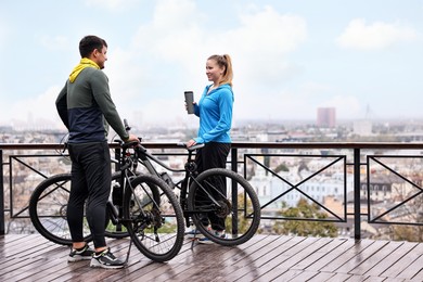 Beautiful happy couple with bicycles spending time together outdoors